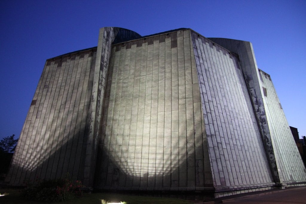 A concrete tower lit from below against a blue night sky