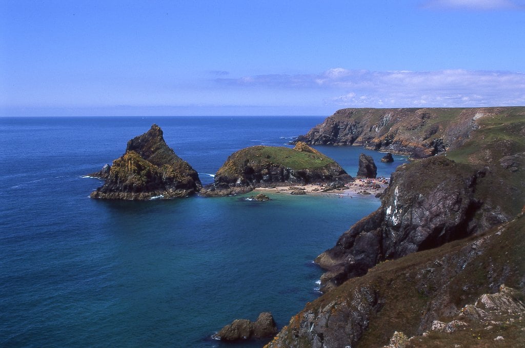 Rock islands in a deep blue bay beneath green headlands