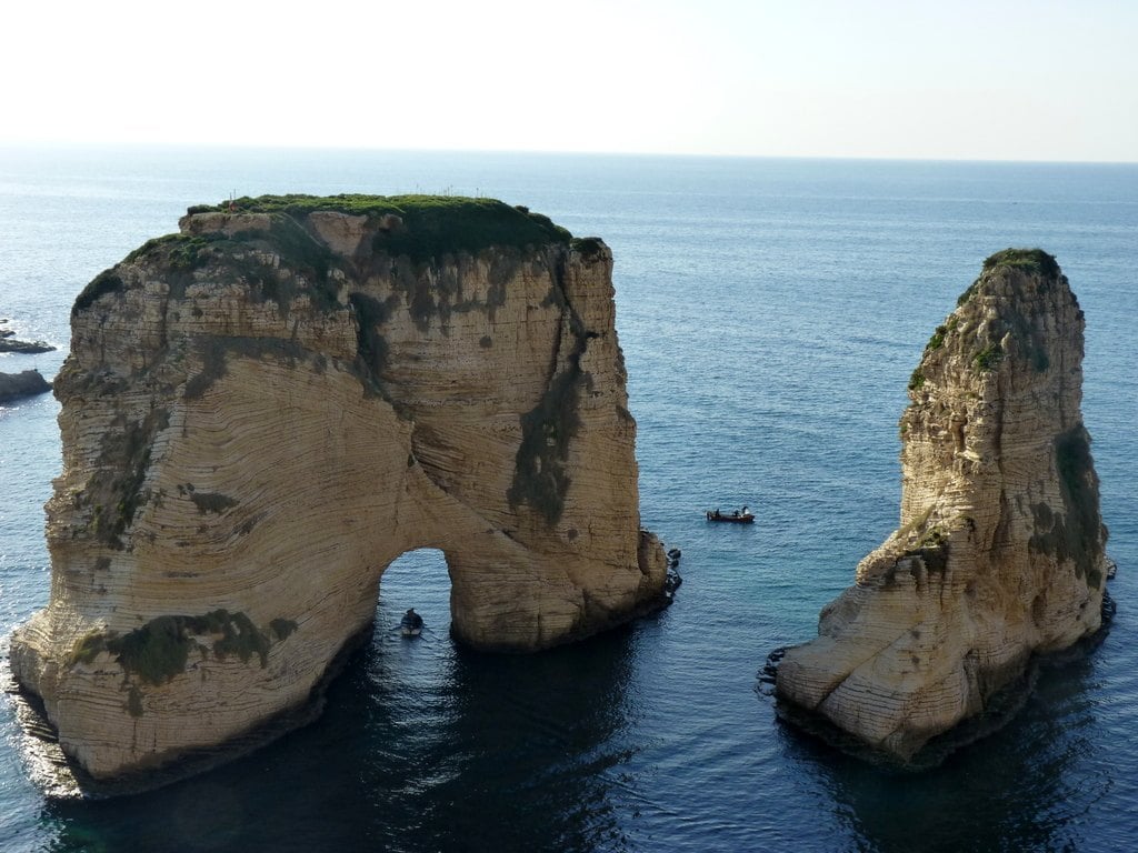 Two limestone stacks, one with an arch, standing in the sea