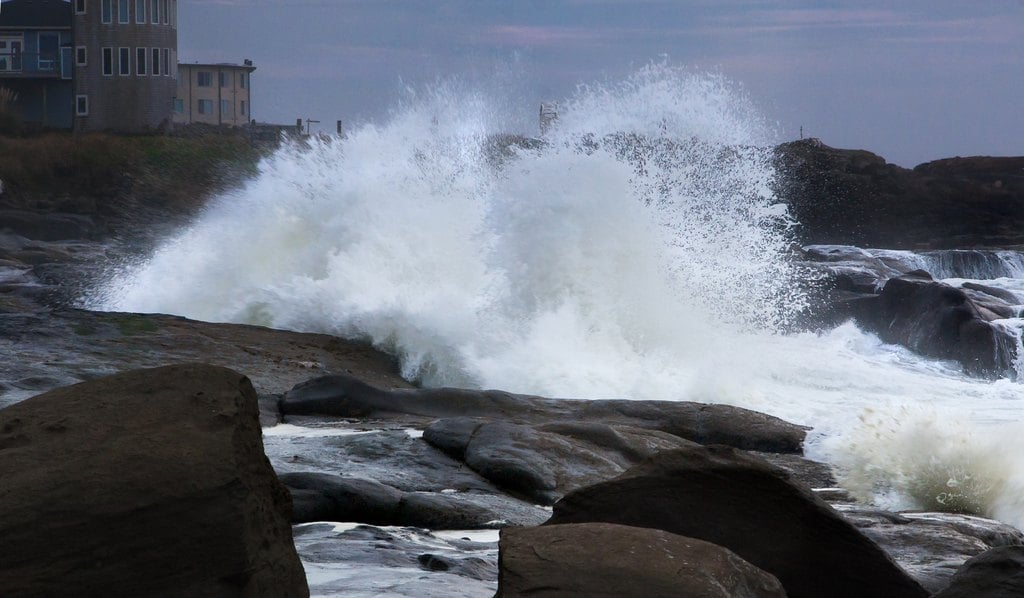 Spray bursting over boulders on a rough shore