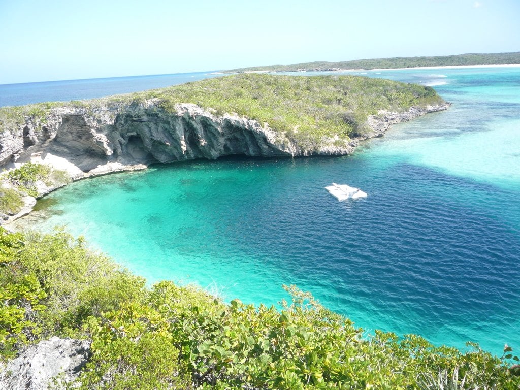 A turquoise lagoon edged by low cliffs and scrub