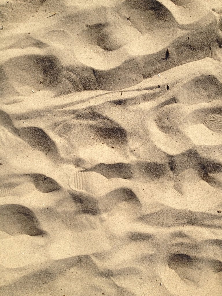 Wind-shaped hollows in pale sand, close up