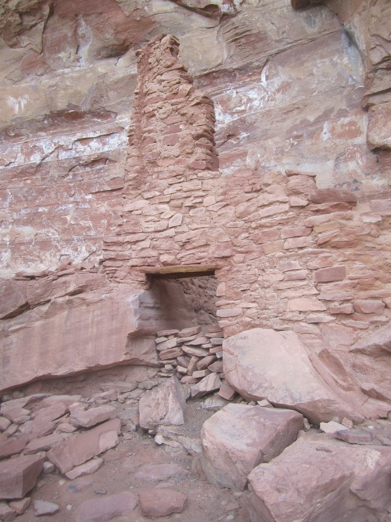 A narrow doorway cut into a red cliff dwelling
