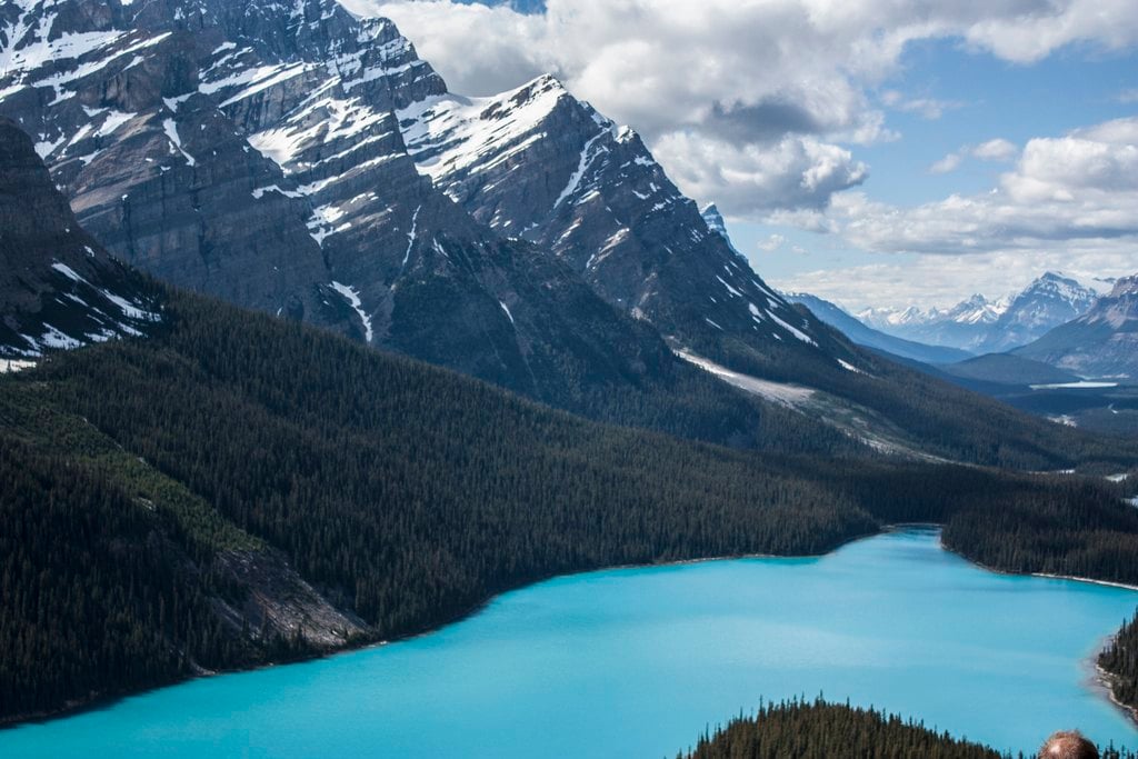 A milky turquoise lake below a dark mountain wall