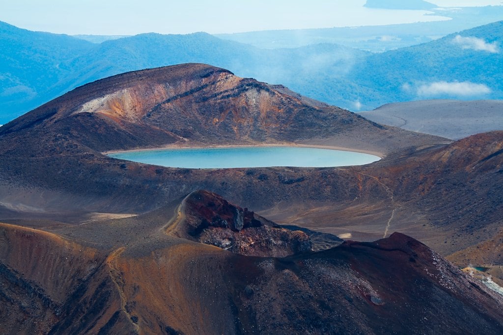 A volcanic crater with a pale lake inside